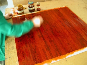 Varnishing the cherrywood burl trim with six coats of traditional gumlack, specially mixed and colored in the workshop.